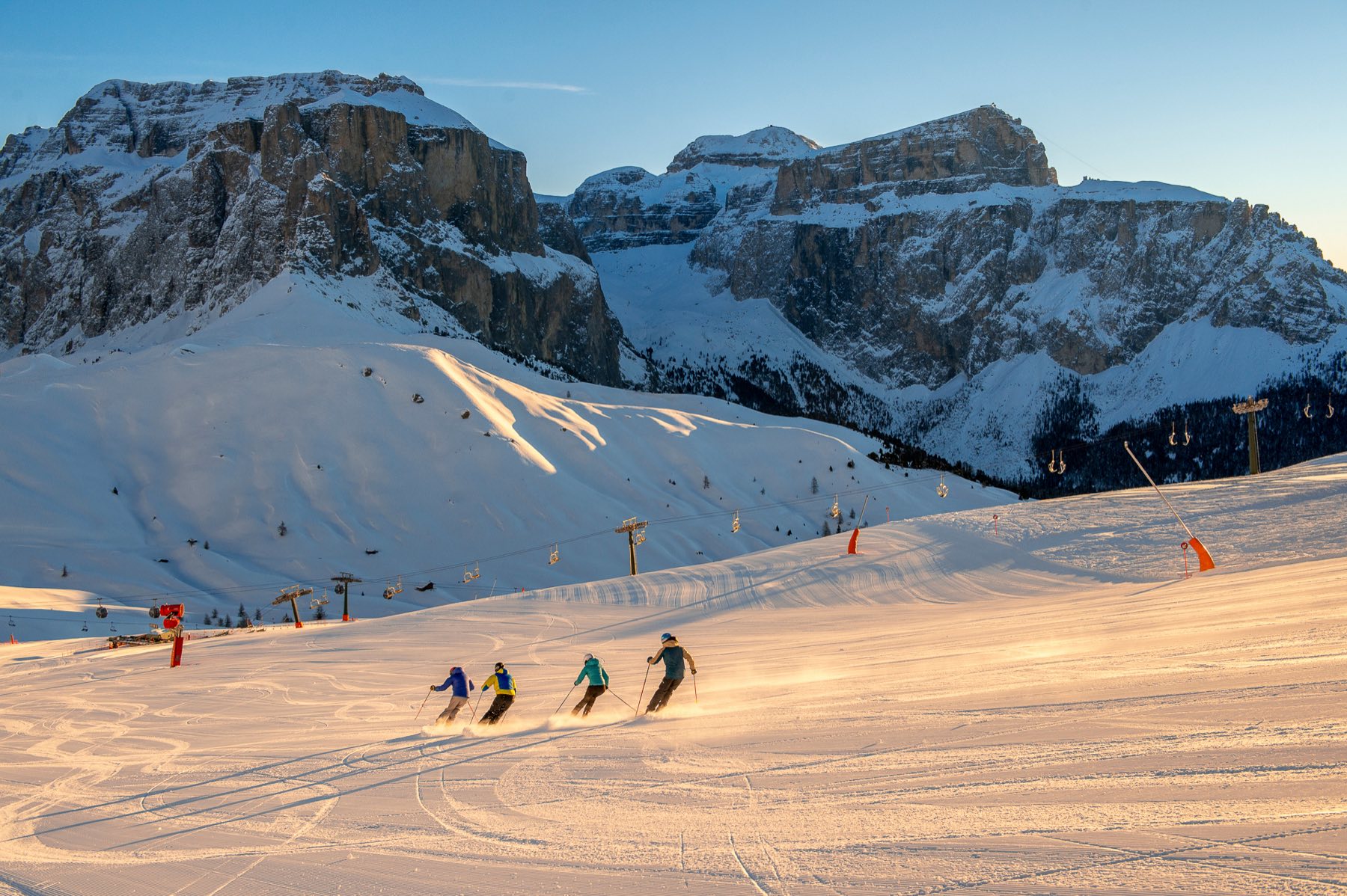 Skiers under the Sella massif in Val di Fassa