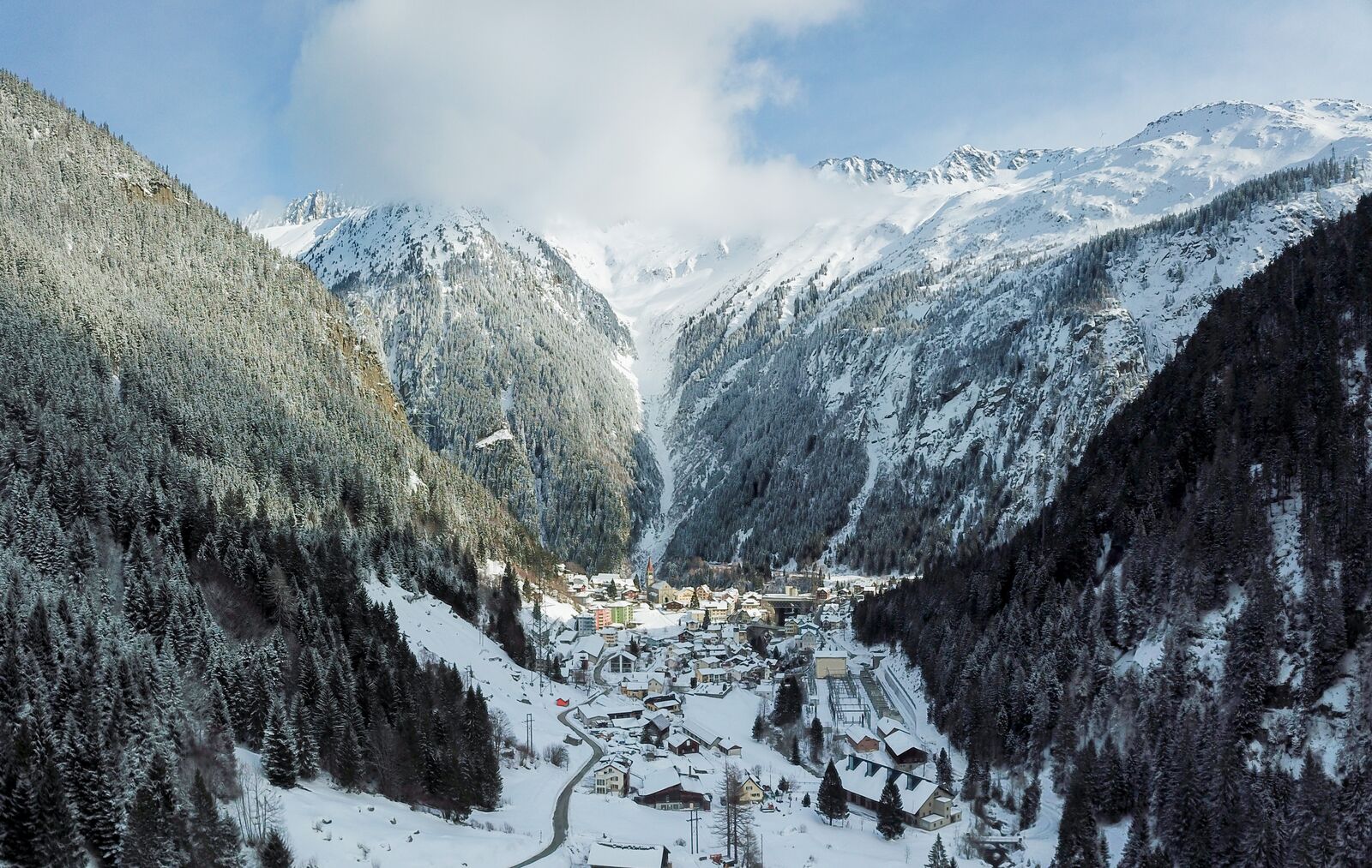 Göschenen tucked into a narrow, forested valley beneath snowy peaks