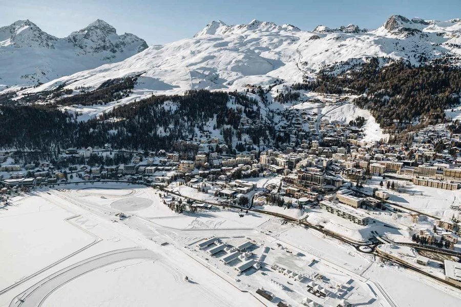 St. Moritz and its snowy ski slopes rising above the frozen lake