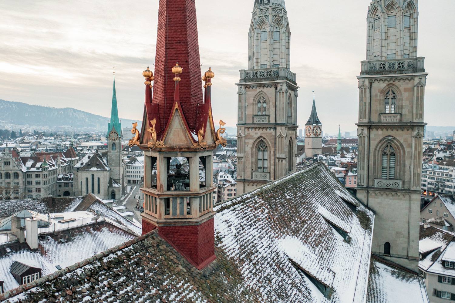 The Grossmünster's twin towers rising above snowy Old Town rooftops