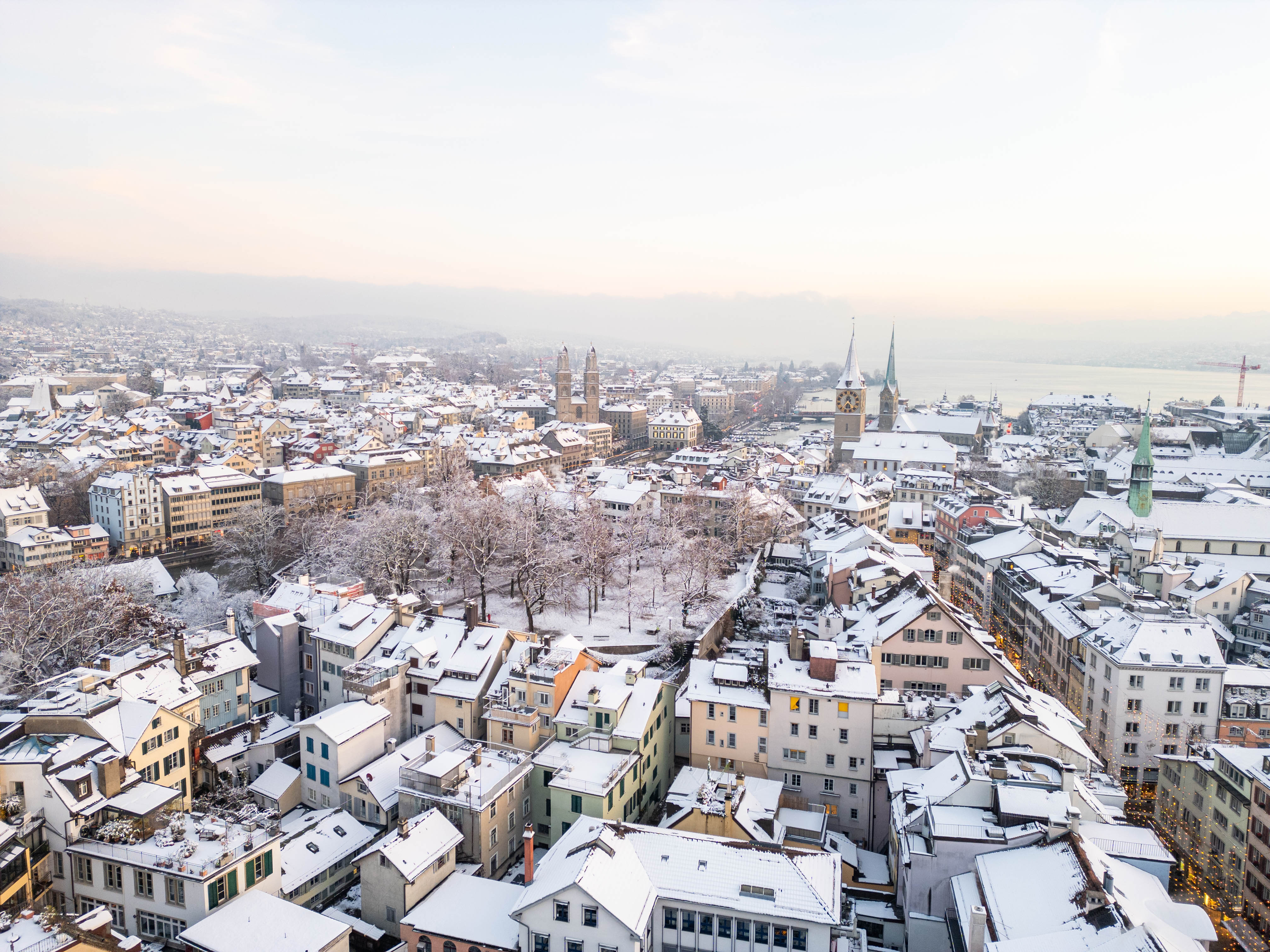 Snow-covered Old Town rooftops with the Grossmünster and Fraumünster towers