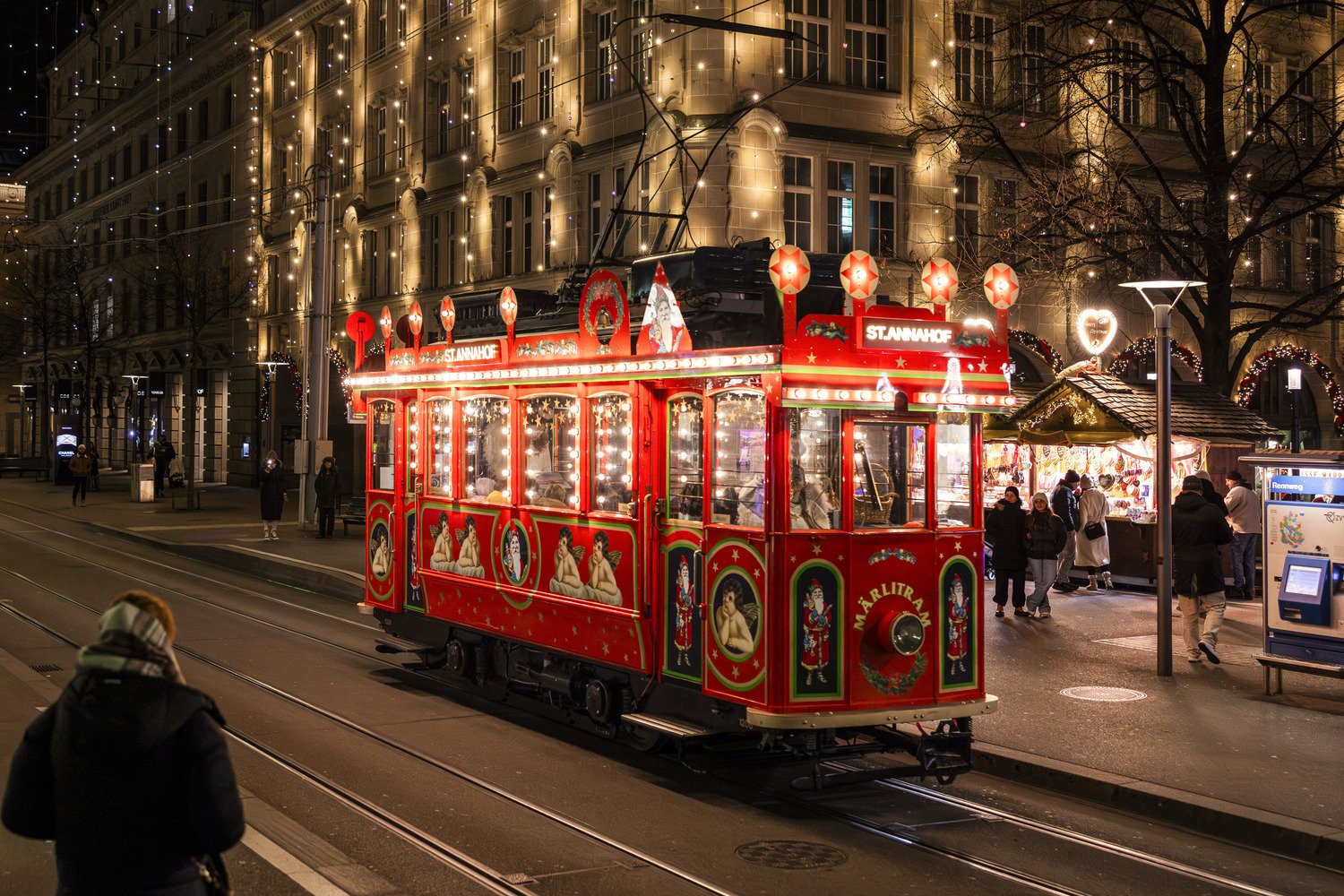 The red Maerlitram Christmas tram lit up on Bahnhofstrasse at night