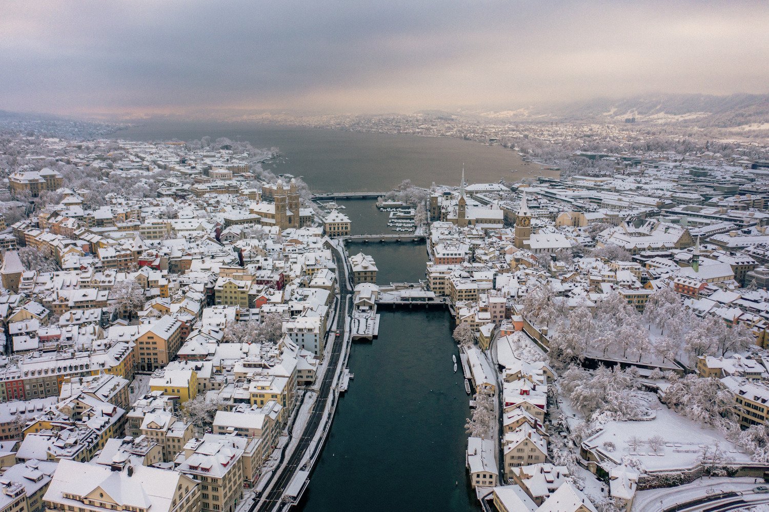 Aerial view of Zurich's snowy Old Town and the Limmat flowing toward the lake