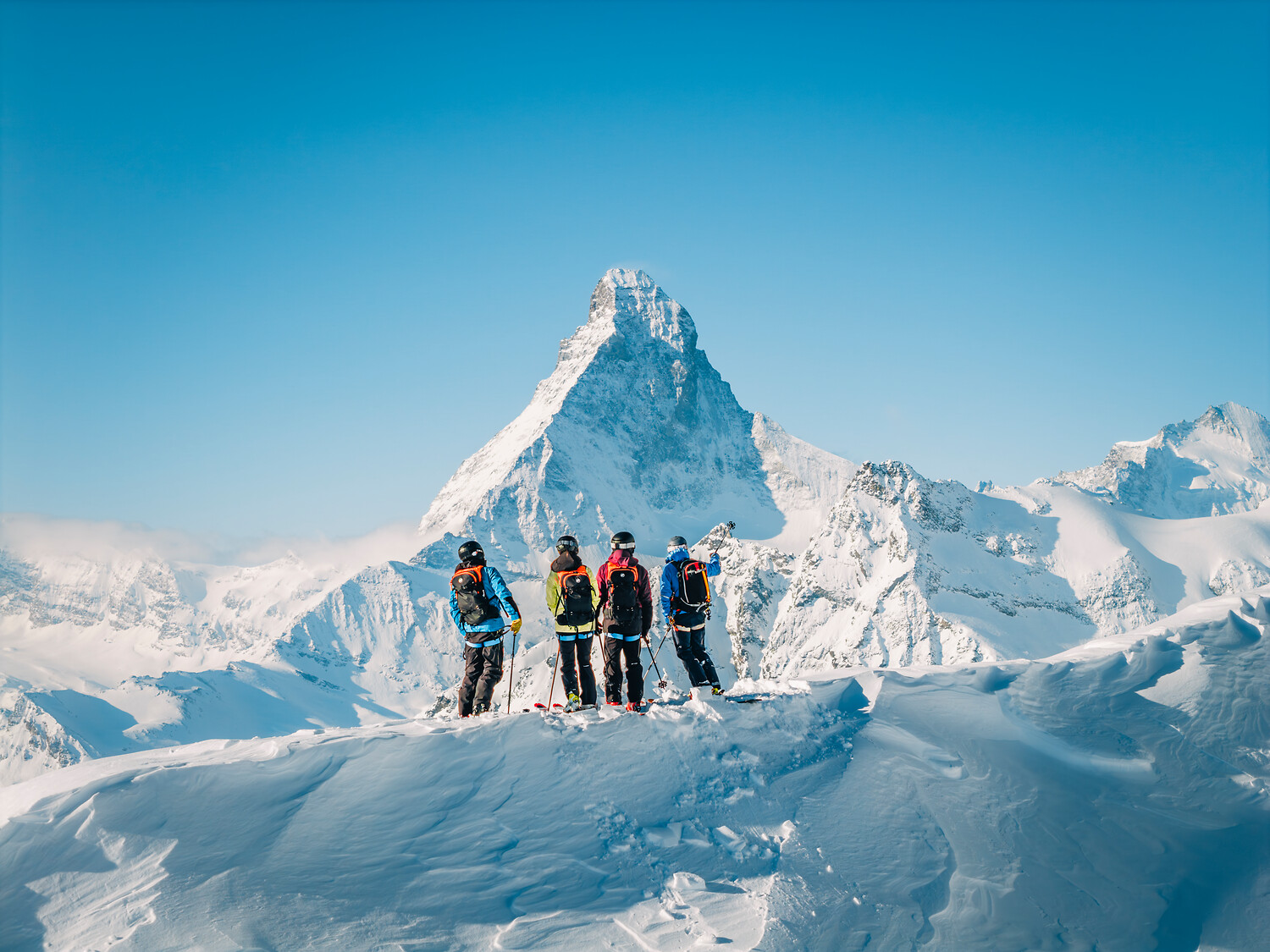 A group of skiers looking out at the Matterhorn from high on the glacier