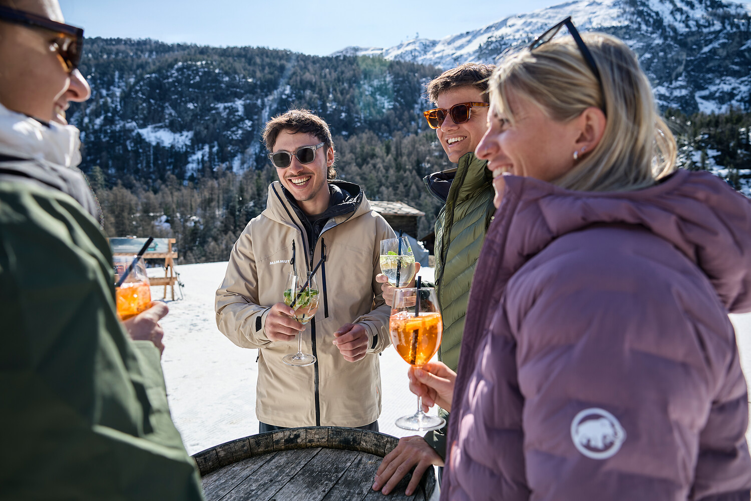 Friends toasting with drinks on a mountain terrace