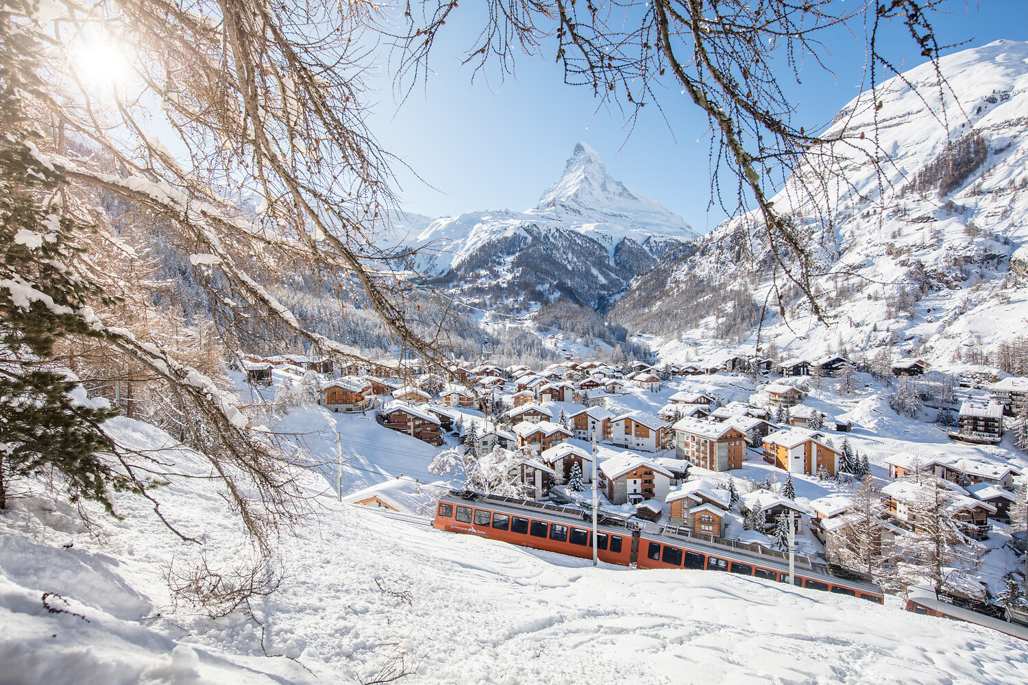 The red Gornergrat cogwheel train above Zermatt with the Matterhorn behind