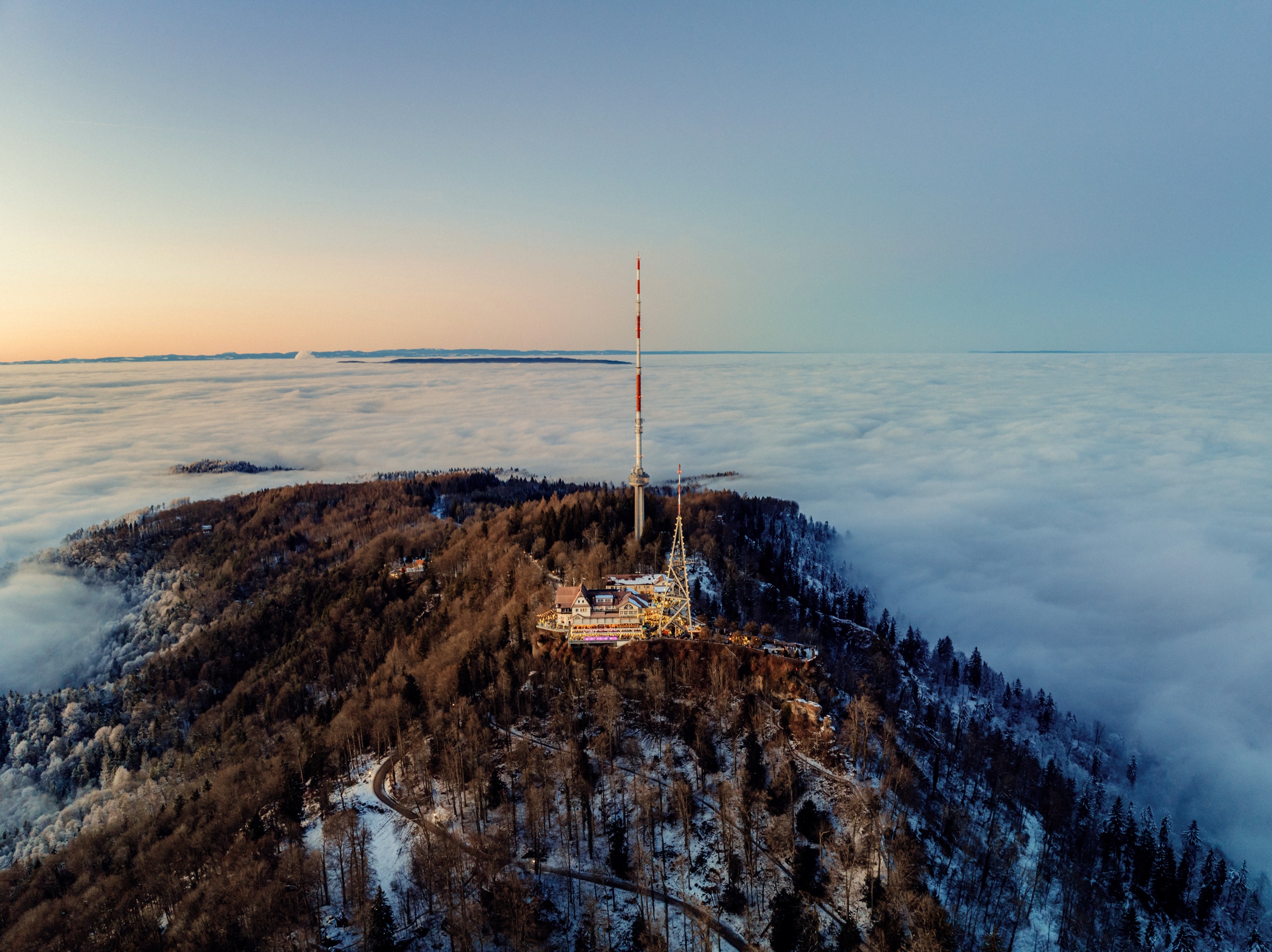 Aerial view of the Uetliberg lookout tower rising above a sea of clouds